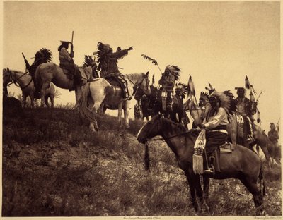 Planning a raid. The Indians, in their impressive typical costumes, come together in extremely picturesque groups. This is a troop from Sioux Ogalala (Oglala), on a hill overlooking the Wounded Knee Valley in the Pine Ridge Reserve, South Dakota. Photo tak by Edward Sheriff Curtis
