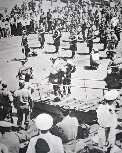 Kilted pipers play ashore from the 1st Battalion Argyll and Sutherland Highlanders from HMS Ceylon at Pusan, 29th August 1950 by English Photographer