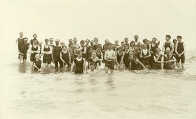 Large group of swimmers standing in the water by English Photographer