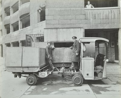 Ossulston Estate: dustmen empty container at the bottom of the rubbish chute by English Photographer