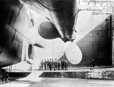 Workmen Standing under One of the Propellers of the Titanic, 31 May, 1911 by English Photographer