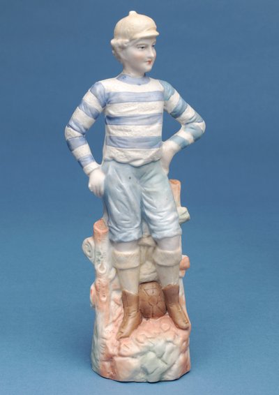 Bisque figure of a boy footballer in blue and white striped kit (ceramic) by English School