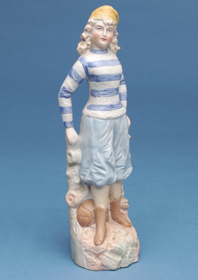 Bisque figure of a girl footballer in blue and white striped kit (ceramic) by English School