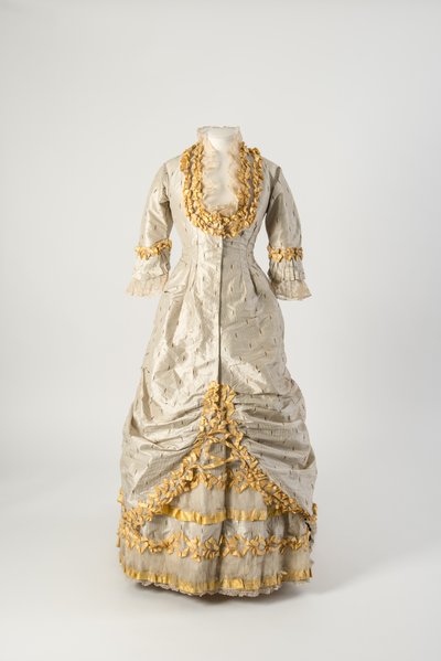Princess line evening dress of grey and white narrow striped silk trimmed with net covered yellow silk taffeta ruched ribbon by English School