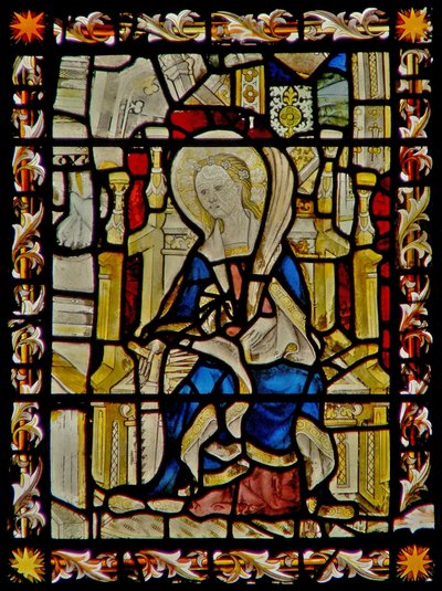 The east window depicting St Faith carrying her emblem the saw by English School