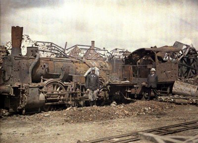 Burnt out locomotive and railway car in front of the ruins of the heavily damaged Vauxrot distillery, Cuffies, Aisne, France by Fernand Cuville