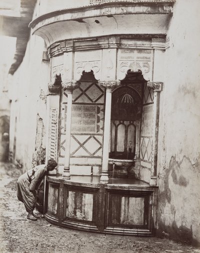 A man drinking from a corner fountain, on a street in Damascus, Syria by Félix Bonfils