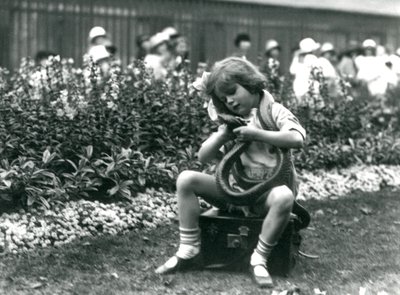 A Young Girl Betty Holding an Eastern Indigo Snake, While Sitting on a Leather Trunk, London Zoo, 1924 by Frederick William Bond