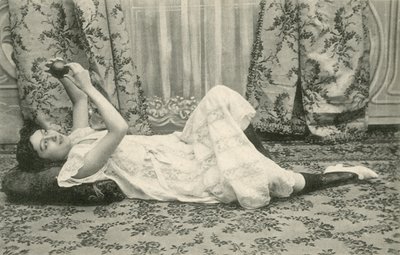 Girl, lying on the floor, holding a ball above her head by French Photographer
