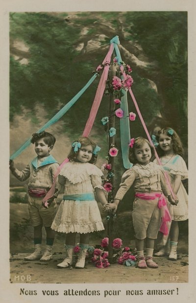Children standing around a maypole (hand-coloured photo) by French Photographer