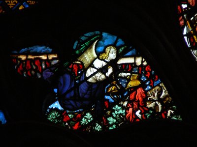 The west rose window depicting a scene from the Book of Revelation: An angel taking the altar fire and casting it upon the earth by French School
