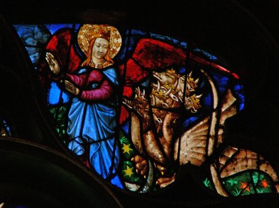 The west rose window depicting a scene from the Book of Revelation: Dragon persecutes the mother of the man child; but she has wings with which to fly into the wilderness by French School