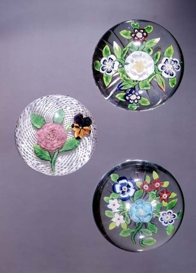 Three paperweights: Clichy rose and pansy with opaque white latticinio ground, and two Baccarat bouquets with star cut bases by French School