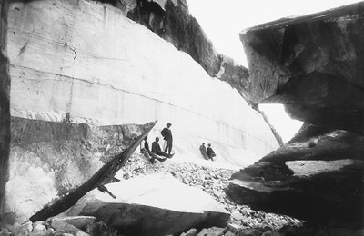 Some men sitting along the walls of a marble quarry, in the Apuan Alps by G. Armani