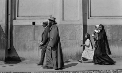 Russian Orthodox priest strolls sidewalk followed by his wife and two children in Moscow by Gilbert H. Grosvenor