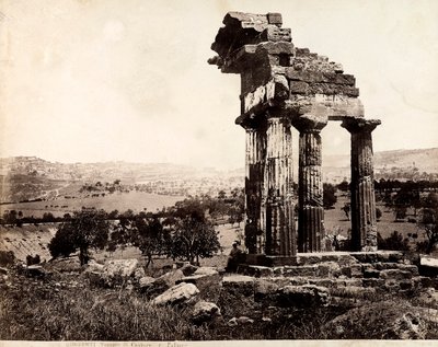 View of the remaining four columns supporting an entablature of the Temple of Castor and Pollux in the Valle dei Templi, Agrigento. A panorama of the city is visible in the background by Giorgio Sommer