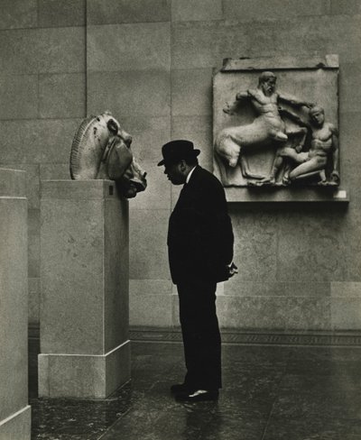 Man looking at sculptures at the British Museum, London 1950s by Godfrey Macdominic