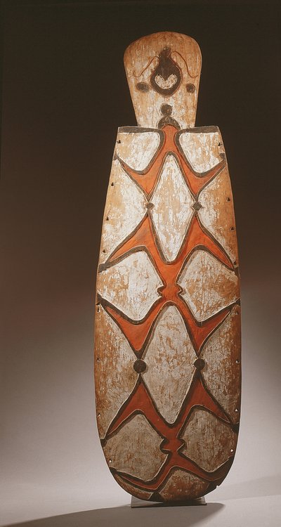 Oval Asmat Shield, Carved in Relief with Stylised Figures, a Mask at the Top by Guinean New