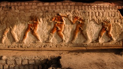 A frieze of naked prisoners of the Moche on the Huaca Cao Viejo walls at El Brujo, a remote complex of pyramid ruins of the Moche - a culture that ruled Peru