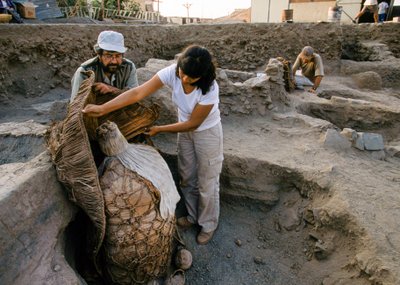 Archaeologists with a mummy bundle found at the school dig site by Ira Block