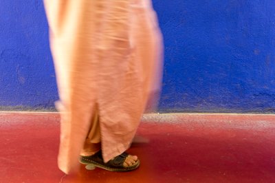 Walking past a blue wall in the Majorelle Garden, Marrakech, Morocco by Ira Block