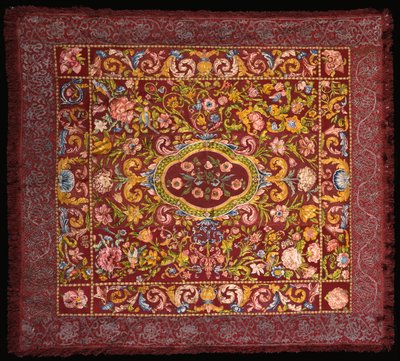 An Italian table carpet embroidered in brightly coloured silks with a central medallion of roses within a field of lilies and larger flowers by Italian School