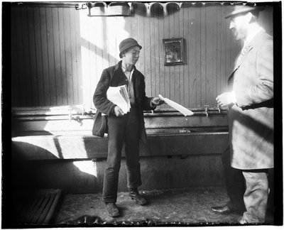 Portrait of a Newsboy Handing a Paper to a Man in What Appears to Be a Restroom at the Duane Street Lodging House by Jacob August Riis