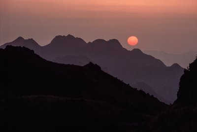 Brilliant crimson, orange sun sets over the Yan Shan Range by James L Stanfield