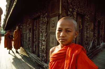 A Young Novice Monk in Front of Carved Teak Panels, Shwenandaw Monastery, Mandalay, Burma by James L Stanfield