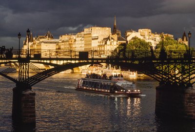 Dark clouds are overhead as a boat passes under the Pont des Arts. Seine River, Paris by James L Stanfield