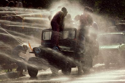 People are sprayed at the Water Festival during Buddhist New Year, Mandalay, Burma by James L Stanfield