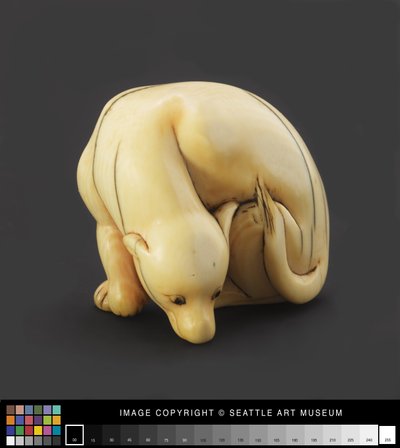 Netsuke modeled as a reclining dog, early 19th century by Japanese School