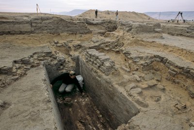 Archaeologist excavates the remains of a woman buried in a wooden coffin next to the Nile, 2005 by Kenneth Garrett
