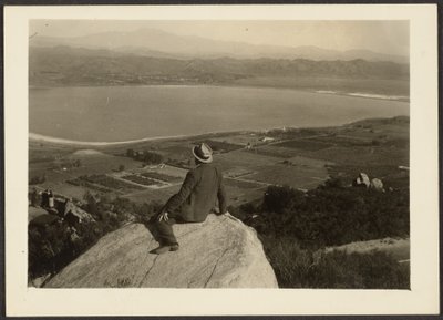 Man on Rock Promontory Overlooking Farmland by Louis Fleckenstein