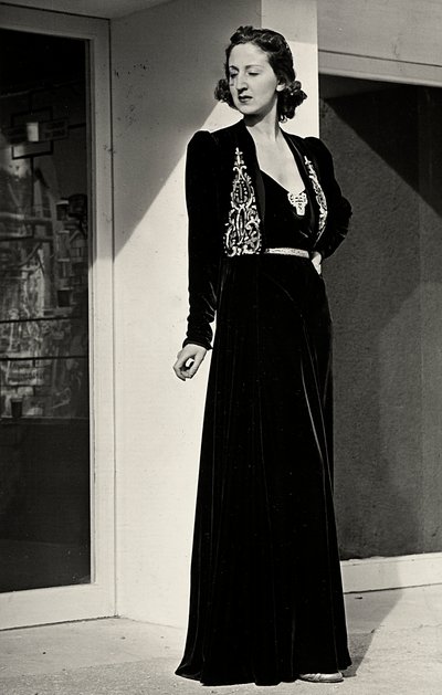 Model wears long evening dress of dark velvet with embroidered decoration, created by the Italian couture house 