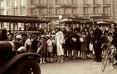 A group of students during a fieldtrip. The photograph shows the children, their teachers and other pedestrians on city street by Mario Castagneri