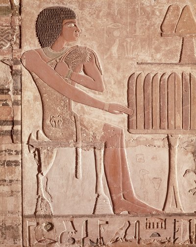 Relief depicting the deceased seated before an offering table with bread by Old Kingdom Egyptian
