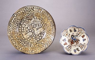 A Sultanabad pottery dish, depicting two seated deer amongst dense leafy motifs by Persian School