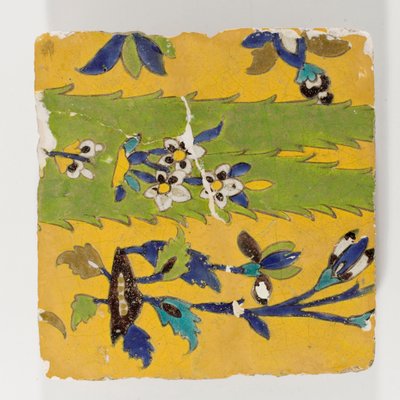 An 18th century Persian pottery tile in yellow by Persian School