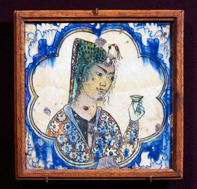 Ceramic tile depicting young woman holding vase by Persian School
