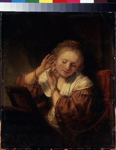 Young Woman Trying on Earrings by Rembrandt Harmensz. van Rijn