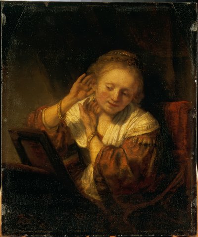Young Woman Adorning Herself with Earrings by Rembrandt van Rijn