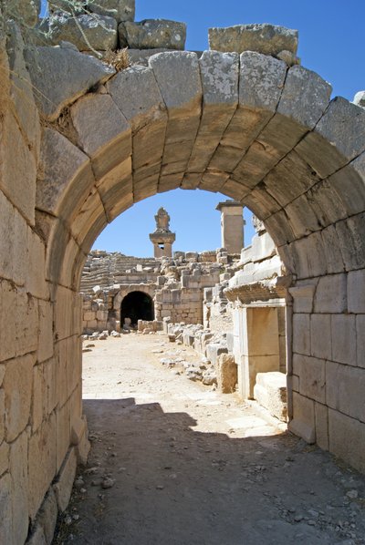 View through the vaulted entrance of the Xanthos theatre into the Orchestra pit, showing pillar and Harpy tomb, Xanthos, Turkey by Roman