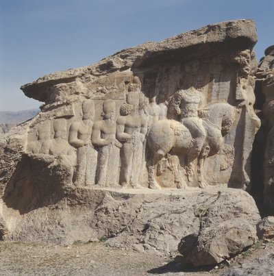 Rock relief depicting Shapur I and his family wearing heraldic emblems on their hats, with a tri-lingual inscription on the horse in Greek, Parthian and Middle Persian by Sasanian