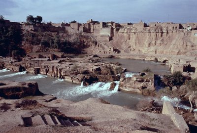 Remains of the Sika bridge-dam-waterway complex on the Gar-Gar River with the city of Shushtar in the background by Sasanian School
