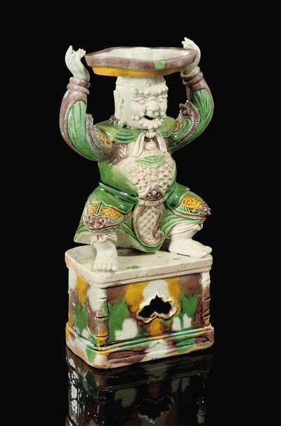 Egg and Spinach Glazed Pricket-Stick, Modelled as a Smiling Immortal with Scrolling Beard, Arms Raised to Support the Quatrefoil Pricket Attachment Balanced on His Head, Kangxi by School Chinese