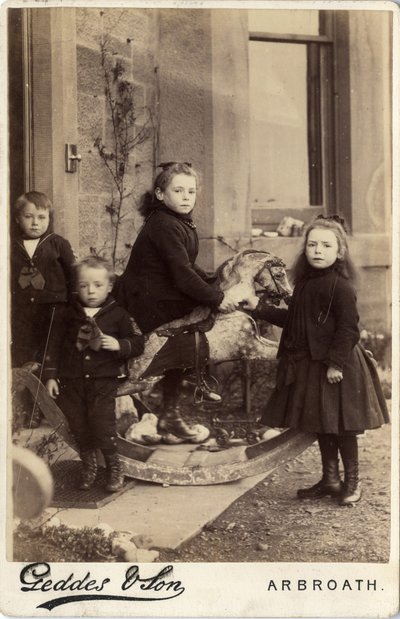 Group of young children and their rocking horse by Scottish Photographer