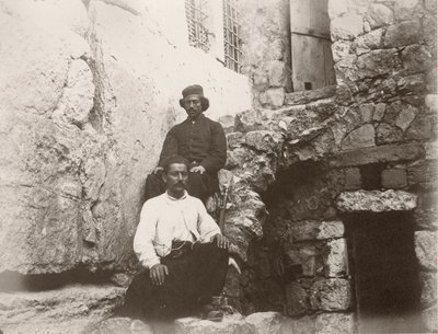 Two men sitting next to the lintel of Barclay