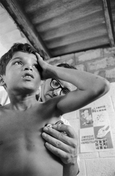 American doctor uses stethoscope to diagnose a sick Ecuadorian child on hospital ship SS Hope by Ted Spiegel