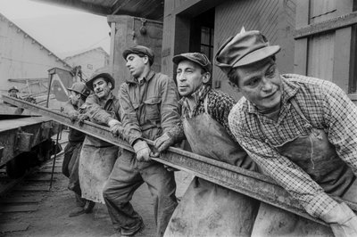 Mine workers pull together to move a heavy steel rail at El Teniente copper mine by Ted Spiegel